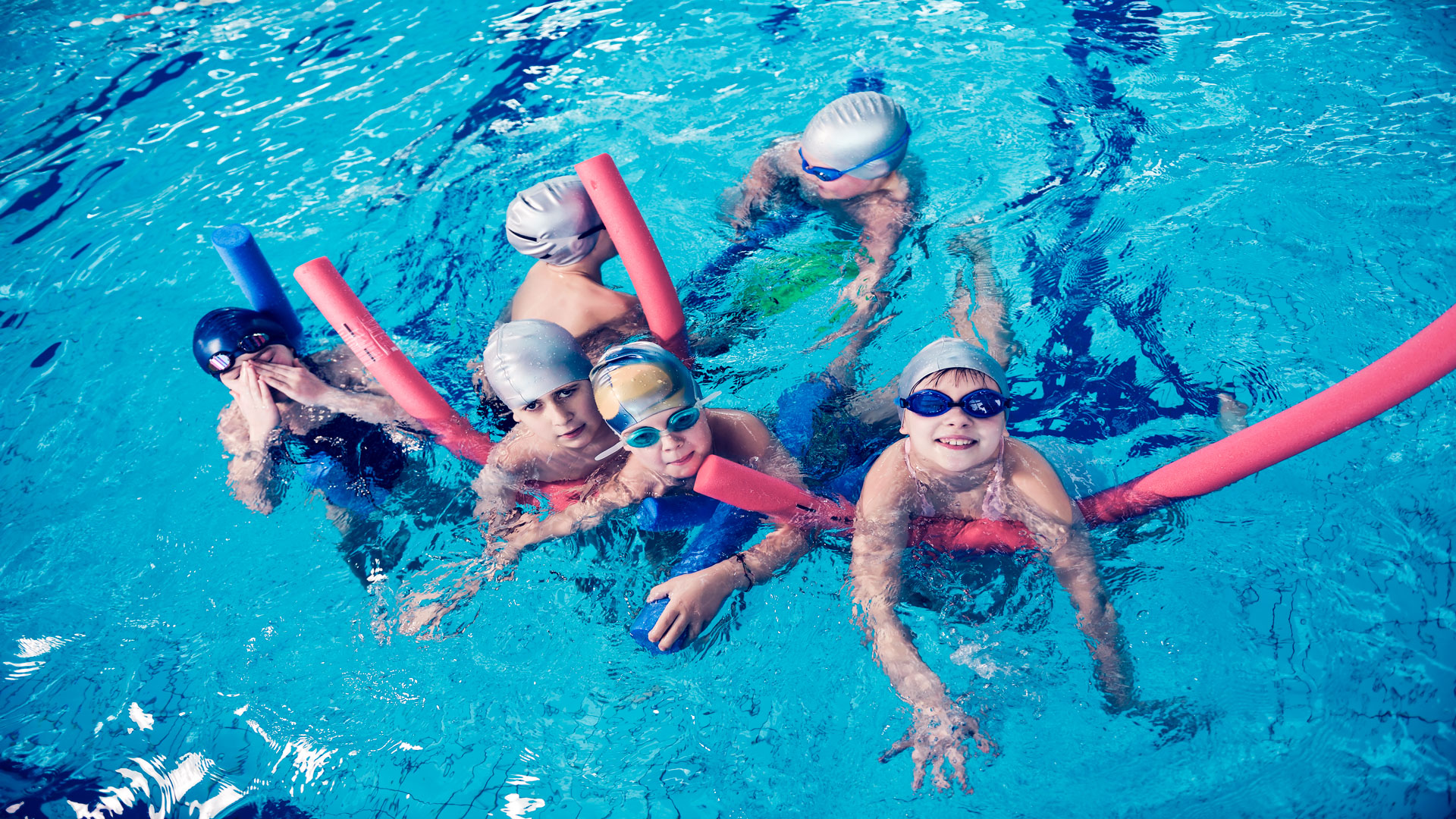 Niños aprendiendo a nadar en la piscina